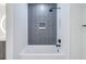 The bathroom's shower and tub are lined with white tile and accented by a gray tile backsplash and black fixtures at 777 3Rd N Ave # 707, St Petersburg, FL 33701