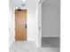 Hallway with light wood door, modern gray tile flooring, and access to multiple rooms at 777 3Rd N Ave # 707, St Petersburg, FL 33701