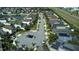 Aerial view of a neighborhood with a community pond, lush trees, and neatly arranged houses at 11656 Lake Blvd, New Port Richey, FL 34655