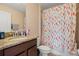 Bathroom vanity with granite countertop, stylish fixtures, and colorful shower curtain at 11656 Lake Blvd, New Port Richey, FL 34655
