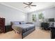 Bedroom with large bed, neutral walls, ceiling fan, and a dedicated workspace at 11656 Lake Blvd, New Port Richey, FL 34655