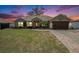 Charming single-story home with well-manicured lawn, attached garage, and welcoming front entrance at dusk at 13416 Algoma Ave, Spring Hill, FL 34609
