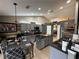 Modern kitchen with gray cabinetry, black countertops, stainless steel appliances, and central island at 13416 Algoma Ave, Spring Hill, FL 34609