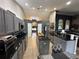 Bright kitchen showcases gray cabinets, black countertops, kitchen island, and stainless steel appliances at 13416 Algoma Ave, Spring Hill, FL 34609