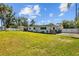 Spacious backyard with lush lawn around the house showcasing ample room for outdoor activities at 1414 Sunset Ln, Lutz, FL 33549