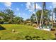 Expansive backyard features a lush lawn and patio seating area with serene water views at 1414 Sunset Ln, Lutz, FL 33549