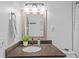 Bathroom with a white tiled shower, vanity with dark countertop and a plant at 1414 Sunset Ln, Lutz, FL 33549