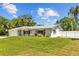 Charming single-story home with a manicured lawn, metal roof, fenced yard and an attached garage at 1414 Sunset Ln, Lutz, FL 33549