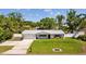 Charming home with a well-manicured lawn, metal roof, and freshly painted exterior at 1414 Sunset Ln, Lutz, FL 33549