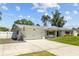Charming single-story home with metal roof, two-car garage, and a well-maintained front yard at 1414 Sunset Ln, Lutz, FL 33549