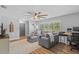Comfortable living room with a gray sectional sofa, ceiling fan, wood flooring and plenty of natural light at 1414 Sunset Ln, Lutz, FL 33549