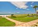 Landscaped walkway leading to a white sand beach with clear blue sky at 1460 Gulf Blvd # 1206, Clearwater Beach, FL 33767
