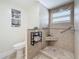 Tiled bathroom with rainfall shower head, safety bars, and art prints, perfect for everyday routines at 1469 S Hillcrest Ave, Clearwater, FL 33756