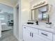 Elegant bathroom vanity with a framed mirror, modern light fixture, white cabinets and a quartz countertop at 1469 S Hillcrest Ave, Clearwater, FL 33756
