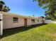 Exterior of home shows orange door, freshly painted walls, and meticulously maintained lawn under a bright blue sky at 1469 S Hillcrest Ave, Clearwater, FL 33756