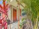 Inviting front entrance with stone accents and an orange front door nestled among lush landscaping at 1469 S Hillcrest Ave, Clearwater, FL 33756