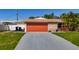 Single story home featuring an orange garage door and a stone facade at 1469 S Hillcrest Ave, Clearwater, FL 33756