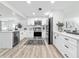 Bright kitchen featuring white cabinets, stainless steel appliances, and a stylish rug on wood-look flooring at 1469 S Hillcrest Ave, Clearwater, FL 33756