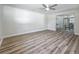 Bright living room featuring new wood flooring, ceiling fan and sliding glass doors to dining area at 1469 S Hillcrest Ave, Clearwater, FL 33756