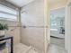 Bathroom's tiled shower with rainfall shower head, grab bars, and window, designed for relaxation at 1469 S Hillcrest Ave, Clearwater, FL 33756