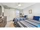 Bright bedroom with two twin beds and a barn door to a bathroom with ample storage at 1535 Nursery Rd # 111, Clearwater, FL 33756