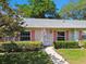 Charming single-story home with pink shutters, lush landscaping, and a welcoming front entrance at 1535 Nursery Rd # 111, Clearwater, FL 33756