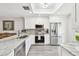 Bright, updated kitchen with stainless steel appliances, white cabinetry, and stone countertops at 1535 Nursery Rd # 111, Clearwater, FL 33756