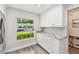 Well-lit kitchen featuring white cabinets, stone countertops, and modern appliances at 1535 Nursery Rd # 111, Clearwater, FL 33756