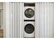 Stacked laundry units tucked behind folding white doors near the hallway at 1535 Nursery Rd # 111, Clearwater, FL 33756
