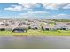 Beautiful backyard view of homes along a lake with fountain, including one with a screened pool at 16709 Barnwood Pl, Bradenton, FL 34211