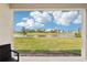 Serene backyard view showcasing green lawn and large pond, as seen from the porch at 16709 Barnwood Pl, Bradenton, FL 34211