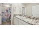 Bathroom featuring double sinks, granite countertops, and a mermaid-themed shower curtain at 16709 Barnwood Pl, Bradenton, FL 34211