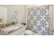Well-lit bathroom featuring granite counters, modern fixtures, and a shower with decorative curtain at 16709 Barnwood Pl, Bradenton, FL 34211