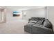 Spacious carpeted bonus room with modern sectional sofa and flat-screen television at 16709 Barnwood Pl, Bradenton, FL 34211