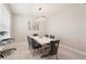 Elegant dining room featuring a modern chandelier and a sleek, white table with seating for six at 16709 Barnwood Pl, Bradenton, FL 34211
