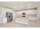 Modern kitchen with white cabinetry, stainless steel appliances, and a granite-topped island at 16709 Barnwood Pl, Bradenton, FL 34211