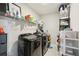 Functional laundry room with modern washer and dryer units and storage shelving at 16709 Barnwood Pl, Bradenton, FL 34211