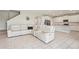 Spacious living room featuring tile floors, a large white sofa, and an adjacent kitchen at 16709 Barnwood Pl, Bradenton, FL 34211