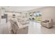 Open-concept living room with tile floors, large windows, and a view of the backyard and kitchen at 16709 Barnwood Pl, Bradenton, FL 34211