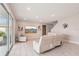 Bright living room featuring a large white sofa, tile floors, and a large window overlooking the backyard at 16709 Barnwood Pl, Bradenton, FL 34211