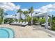 Resort-style pool area with comfortable lounge chairs, shaded cabanas, and lush landscaping under a clear sky at 16709 Barnwood Pl, Bradenton, FL 34211