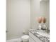 Chic powder room with granite counter, modern fixture, and white vanity at 16709 Barnwood Pl, Bradenton, FL 34211