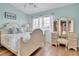 Bright bedroom showcases an elegant vanity, two windows, and a comfortable bed at 17960 Gulf Blvd # 104, Redington Shores, FL 33708