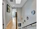 Bright hallway features light hardwood floors, staircase with black railing, and decorative wall mirrors at 17960 Gulf Blvd # 104, Redington Shores, FL 33708