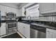 Compact kitchen with stainless steel appliances and black and white tile accents at 17960 Gulf Blvd # 104, Redington Shores, FL 33708