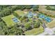 Aerial view showcasing tennis courts, a community pool, and surrounding greenery at 19139 Cypress Reach Ln, Tampa, FL 33647