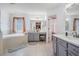 Bright bathroom featuring double vanity, soaking tub, and neutral tile flooring at 19139 Cypress Reach Ln, Tampa, FL 33647