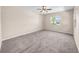 Large bedroom with neutral walls, plush carpeting, ceiling fan, and bright windows with a view of the outdoors at 1969 Wolf Laurel Dr, Sun City Center, FL 33573