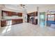 Modern kitchen with stainless steel appliances, dark wood cabinets, tile backsplash, and view of sunroom through sliding doors at 1969 Wolf Laurel Dr, Sun City Center, FL 33573
