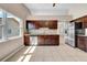 Eat-in kitchen with dark wood cabinets, granite countertops, stainless steel appliances, and natural light at 1969 Wolf Laurel Dr, Sun City Center, FL 33573